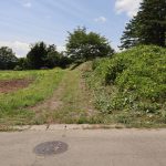 物件東側の舗装公道から物件への入口を撮影。正面の道路が幅員2.5ｍ公道。