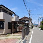 物件東南側から北方向を撮影。建物東側に屋根付きカーポートあり。道路は幅員約4.5ｍの舗装公道。