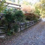 物件南側公道の西側から東方向を撮影。道路との擁壁には長野県辰野町から取り寄せた焼酎樽を使用しています。