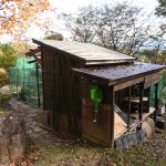 敷地南西側に建つ物置小屋。奥の緑色の網の部分が菜園。