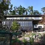 建物南側から撮影。正面左側の黒い窓ガラス部分がサンルーム。建物北側は松林。