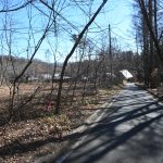 物件北西側公道(北杜市道長坂小荒間24号線)から南方向を撮影。正面方向が甲斐小泉駅方向。